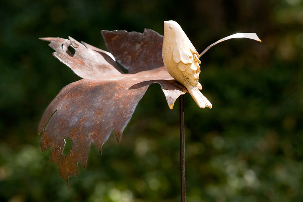 Yellow bird sitting on a leaf metal product